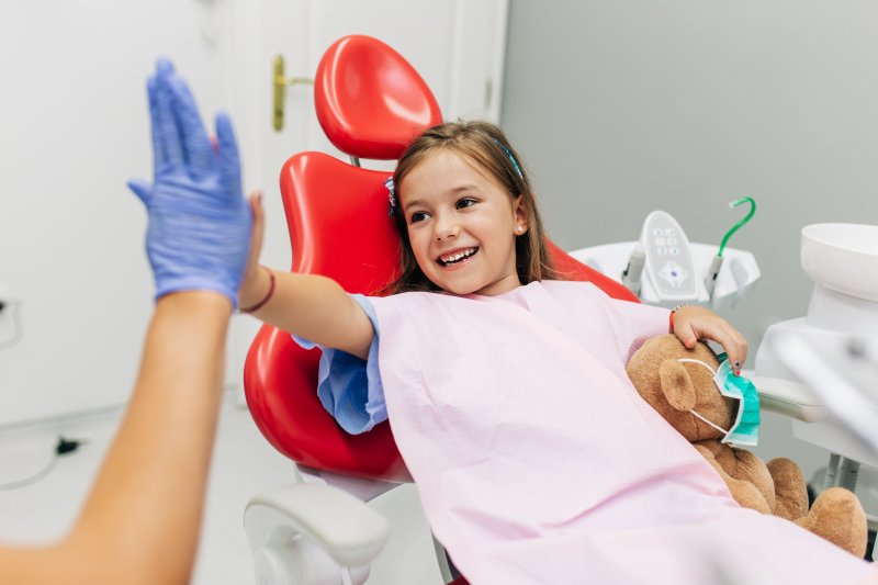 Little girl high fiving dentist after oral conscious sedation for kids in Scottsdale