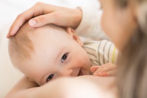 Happy baby breastfeeding after undergoing successful frenectomy