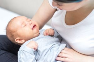 Mom holds distressed baby